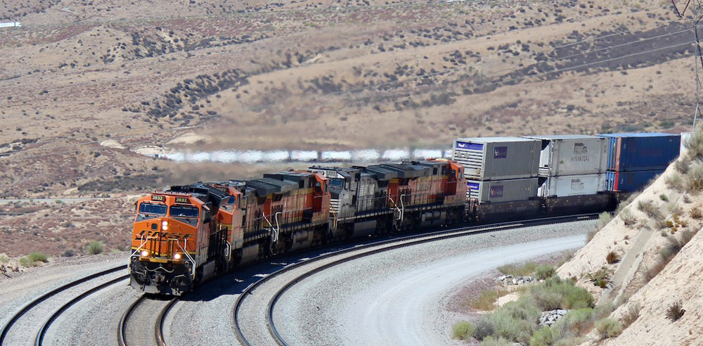 Intermodal train with four locomotives rounds curve