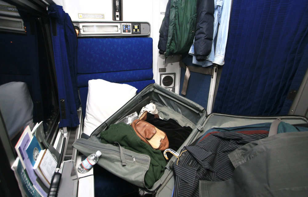 Suitcase and other belongings covering most of space in roomette