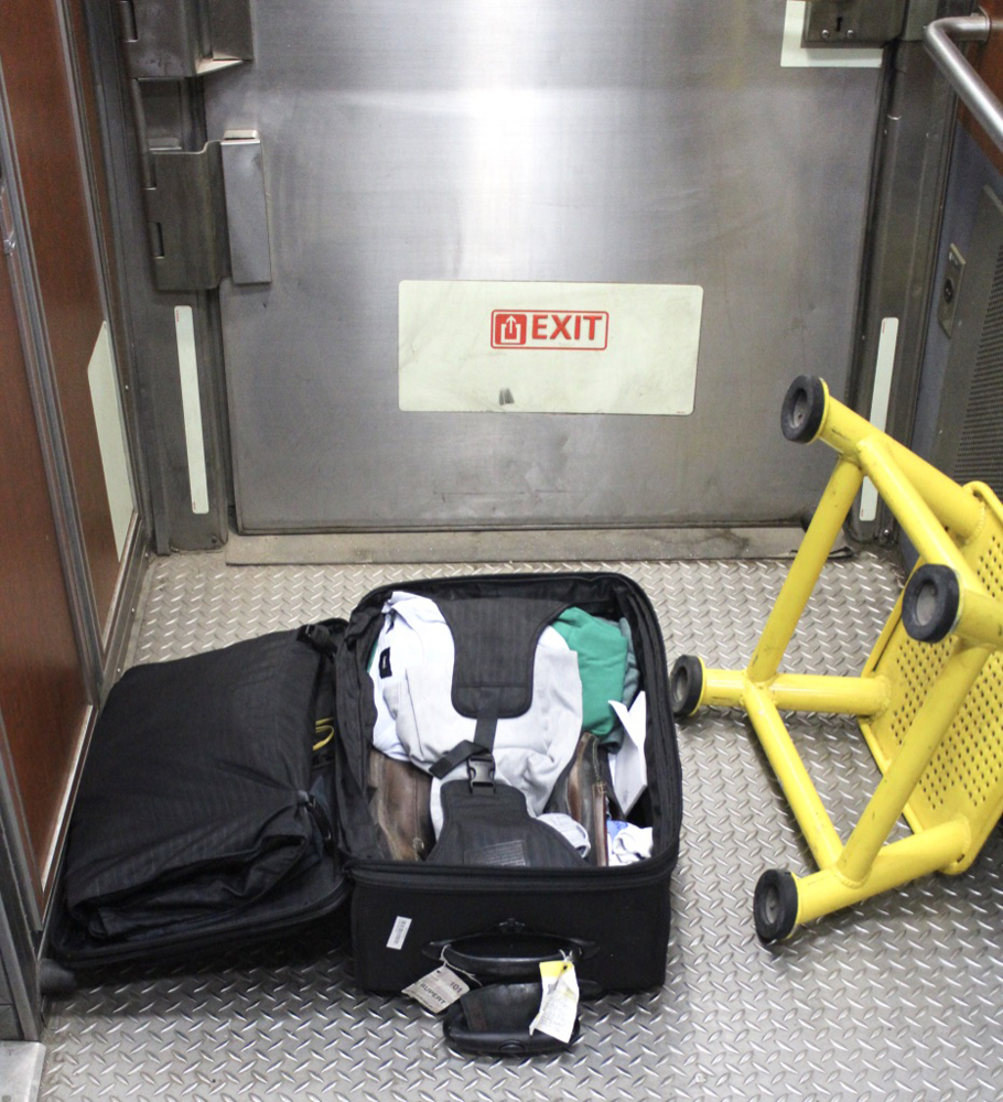 Open suitcase in corridor of passenger car, next to end door