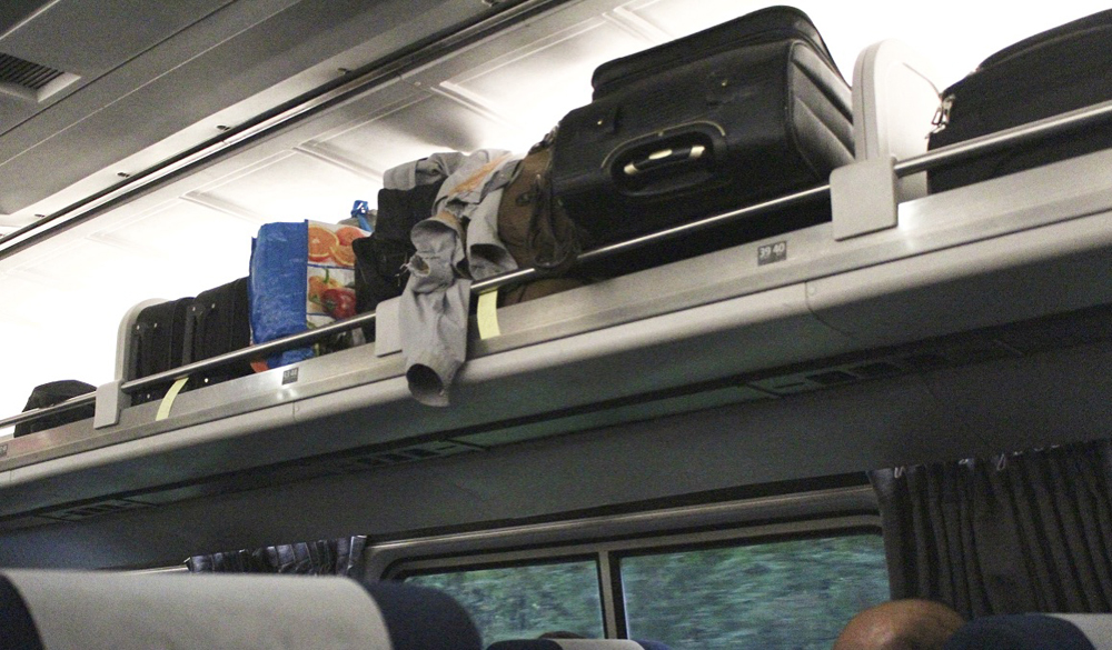 Luggage rack crowded with bags and other items