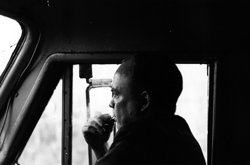 Black and white photo of man in locomotive cab