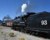 two steam locomotives side by side in railroad yard 