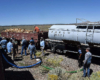 Crews loading wood and water into a train.