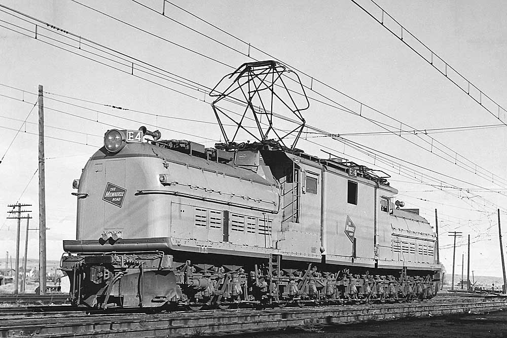 Center-cab electric passenger locomotive stands alone with pantograph raised