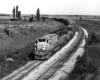 Freight train leans into a curve as seen from an overpass