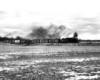 steam locomotive pulls short train through snow-covered fields