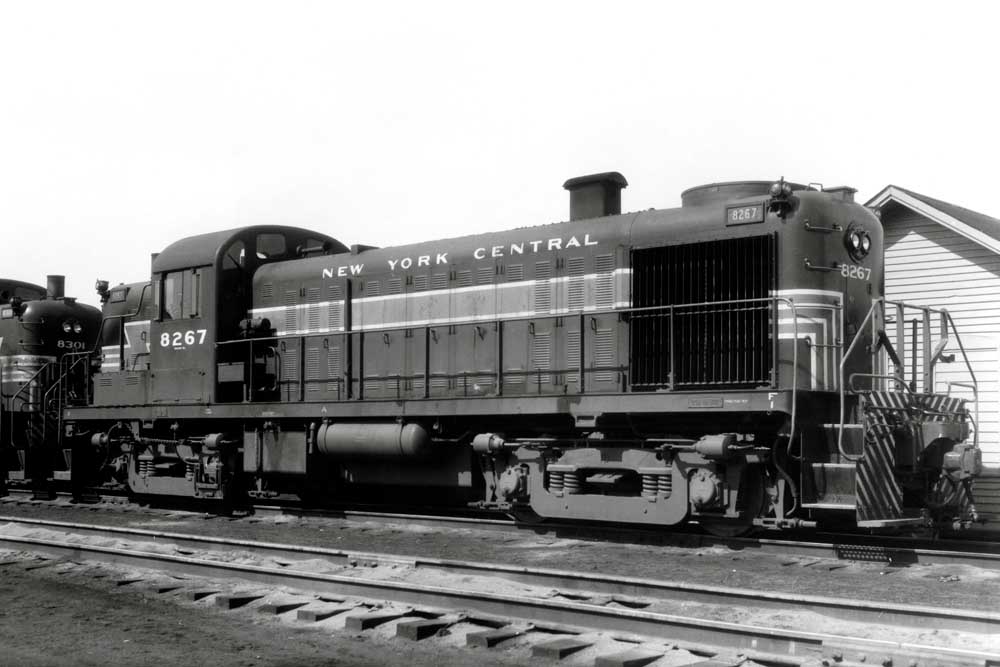 Black and white photo of hood-first diesel locomotive with lightning stripe livery