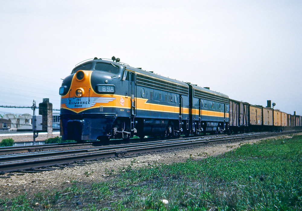 Color three-quarter-angle photo of two streamlined diesel locomotives on freight train
