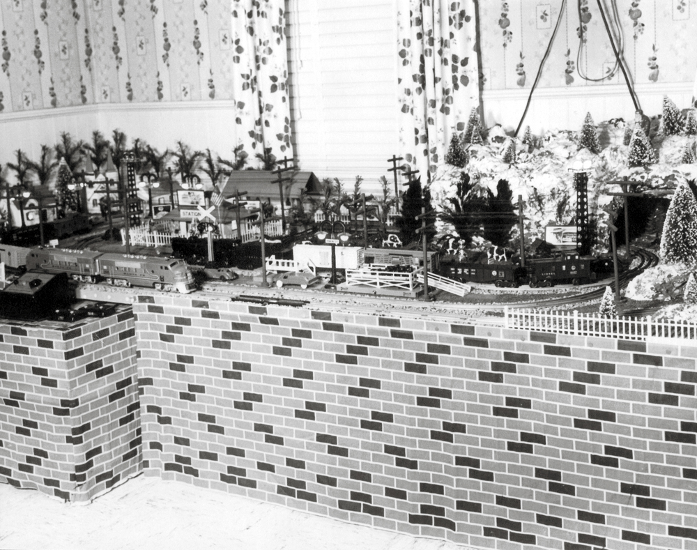 Black-and-white photograph of vintage toy trains in winter holiday scenes