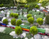 Long train among junipers on a garden railroad