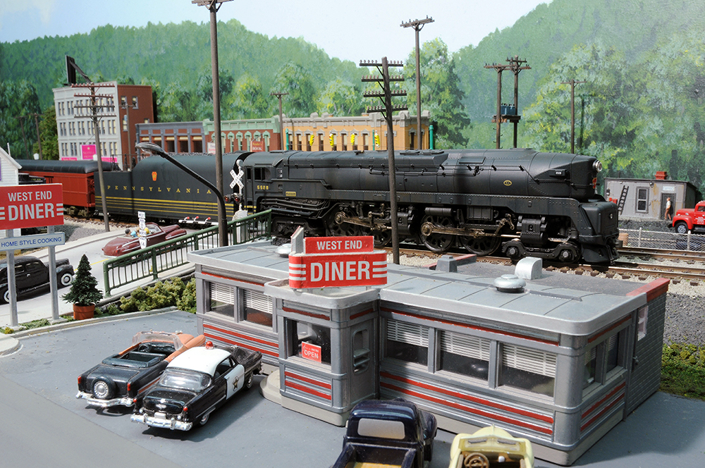 A train passes behind a busy vintage restaurant