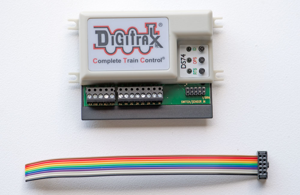 The Digitrax Quad Switch Stationary Decoder with a ribbon cable