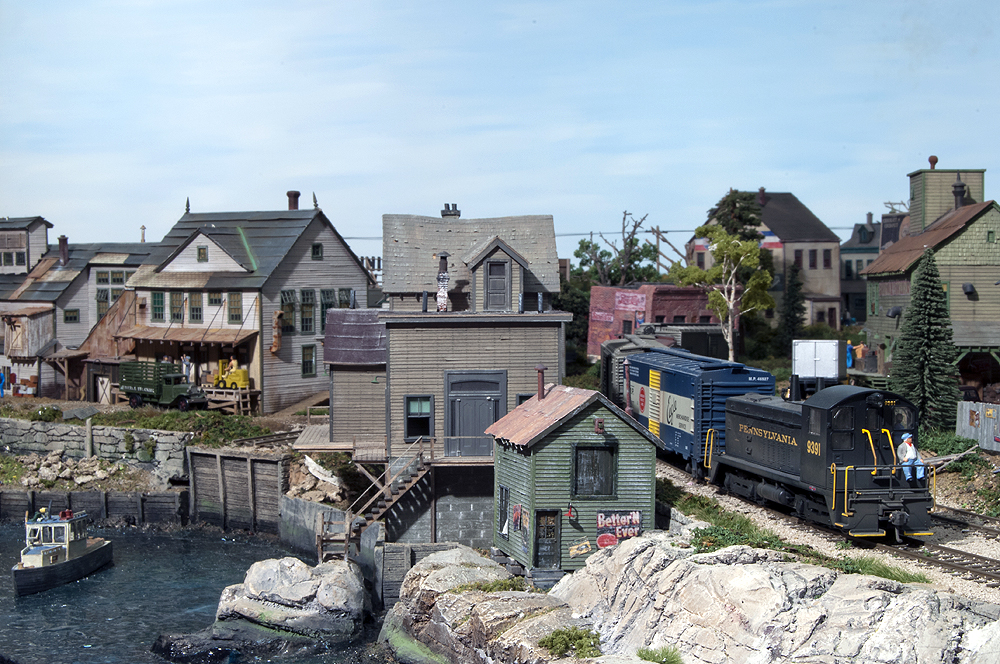 A train going along a town on the water's edge