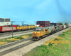 A foreground yellow Union Pacific freight train splits a distanct signal bridge in a relatively flat scene in N Scale.