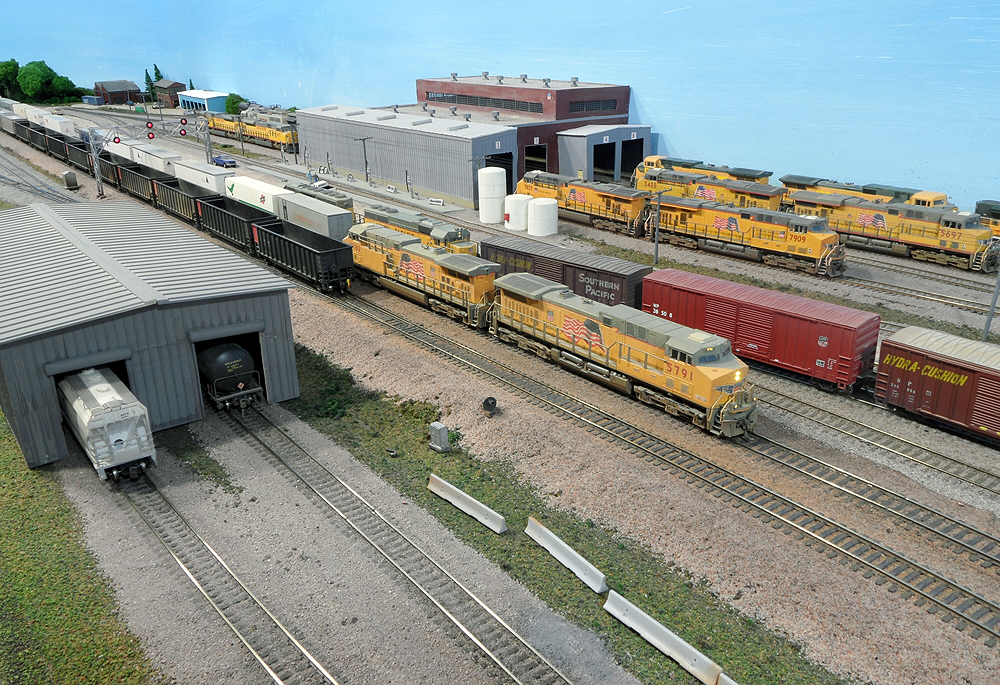 Multiple yellow Union Pacific locomotives in a rail yard.