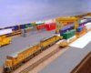 Yellow Union Pacific locomotives at the end of a freight train in a container terminal.