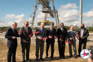 Men in a line cutting ribbon to celebrate new intermodal facility dig