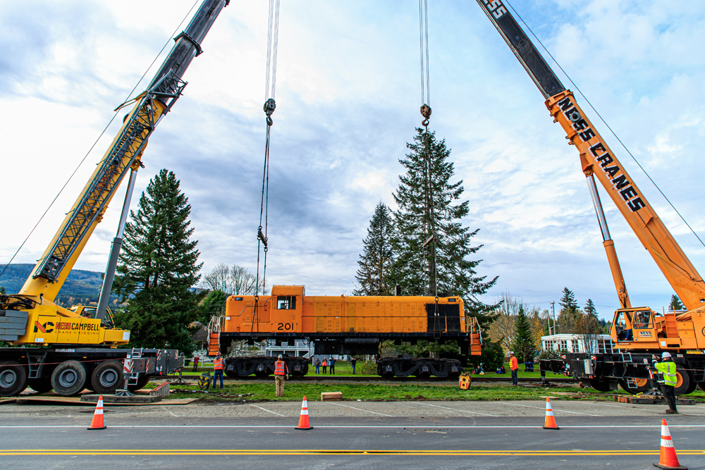 Orange diesel suspended by cranes
