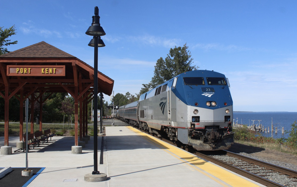 Amtrak train arrives at shelter across tracks from lake