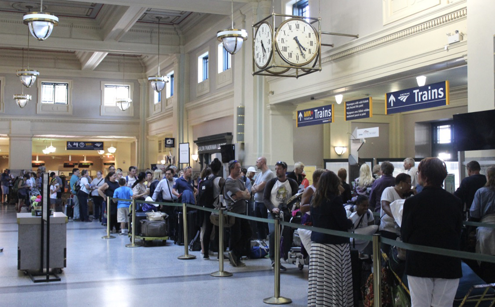 People waiting in line inside passenger station