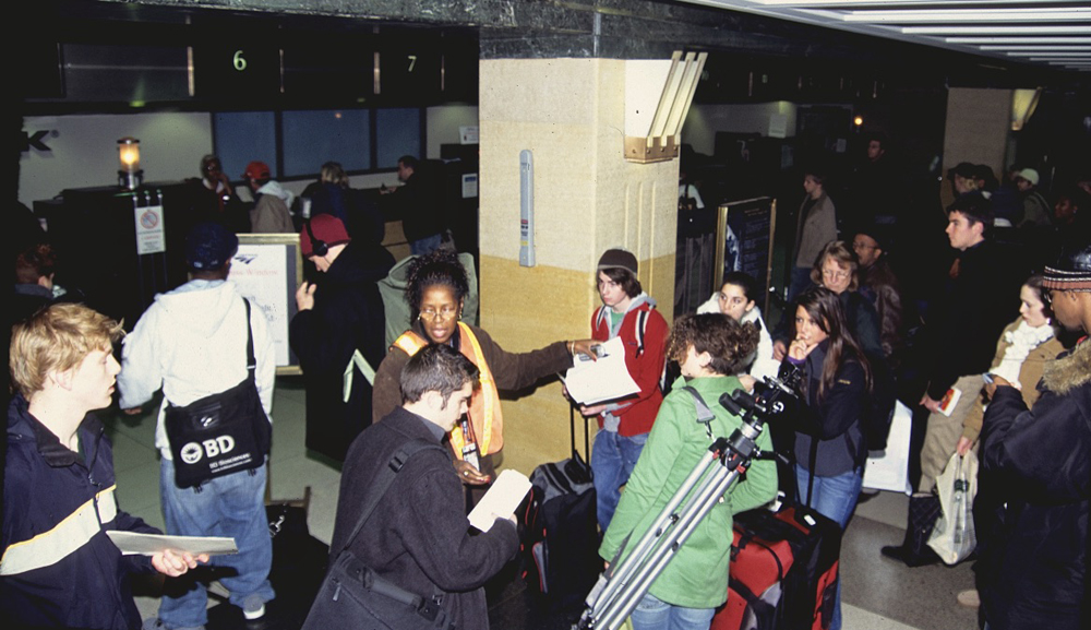 Woman directs passengers at station. It is one of many similar scenes of Amtrak trains during the holidays.