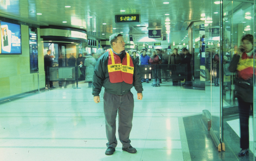 Man wearing day-glo orange vest in station 