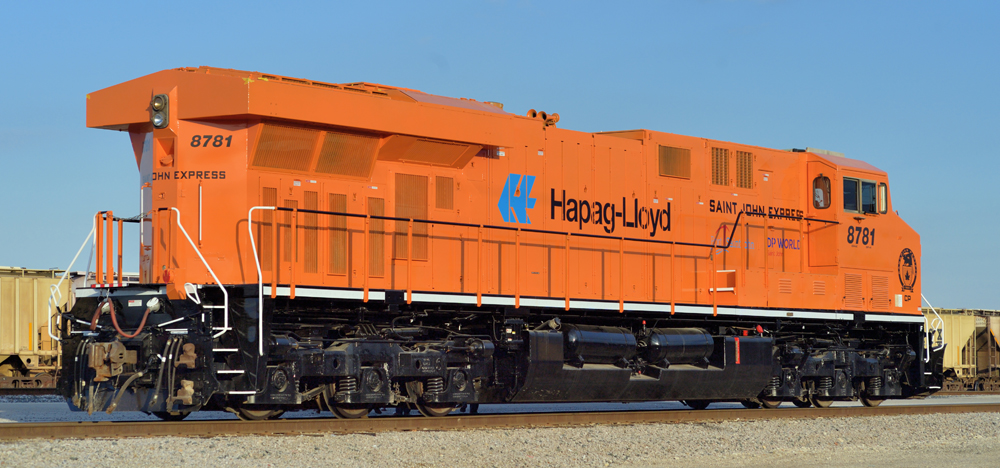 Orange locomotive lettered for shipping company.