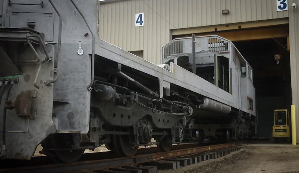 Frame and cab of locomotive outside shop building