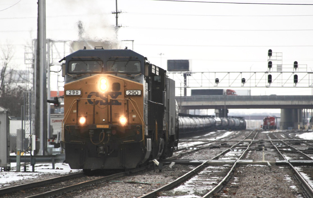 Blue and yellow locomotive on train of tank cars