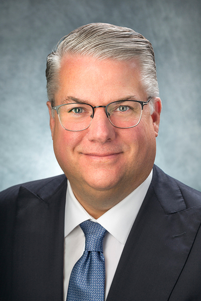 Man with glasses in coat and tie