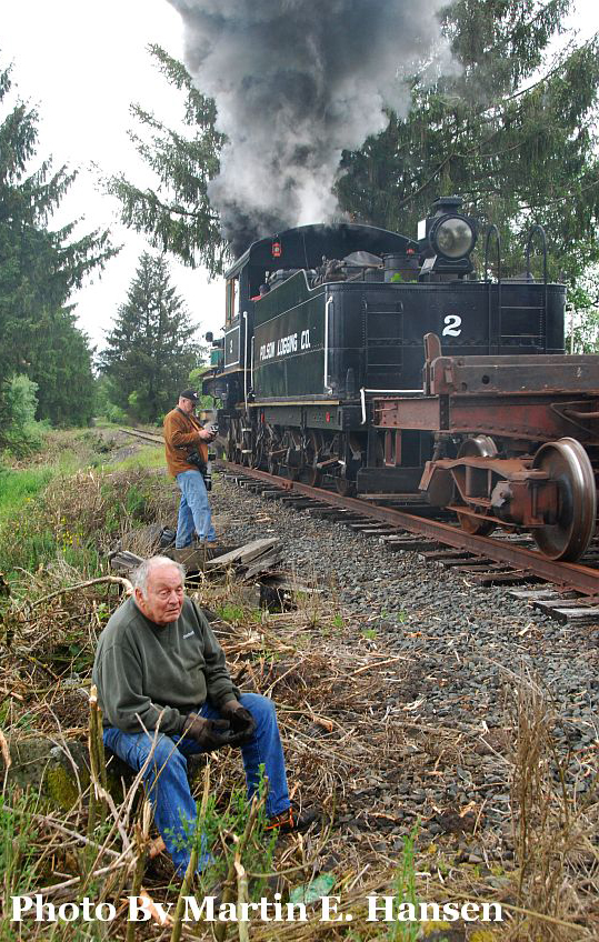 Man sitting next to steam locomotive