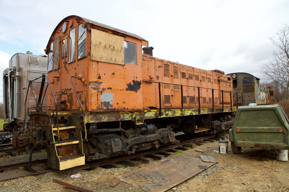 Orange locomotive with boarded-up cab