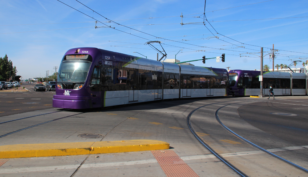 Purple and silver light rail train rounds 90-degree curve