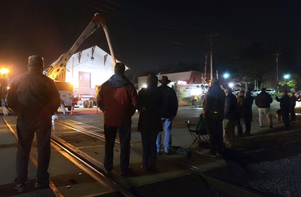 People standing in darkness looking at well-lit building