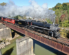 Steam locomotive with passenger train on bridge