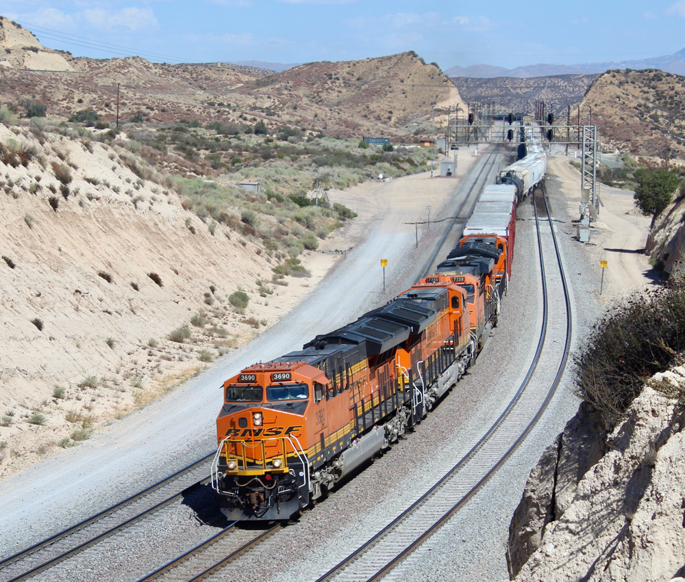 Train with orange locomotives changing tracks at crossover