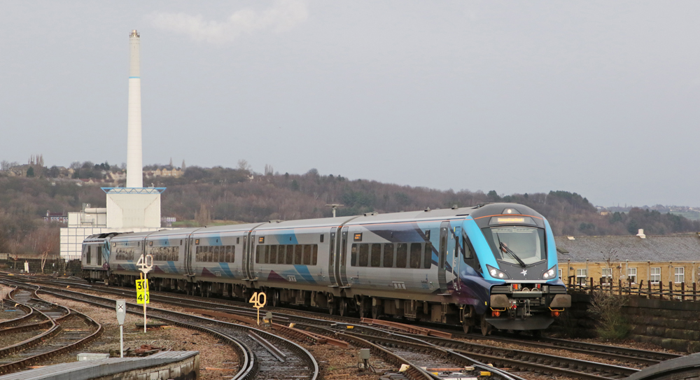 Silver train with blue trim approaches station