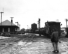 Man stands in street after short train passes.