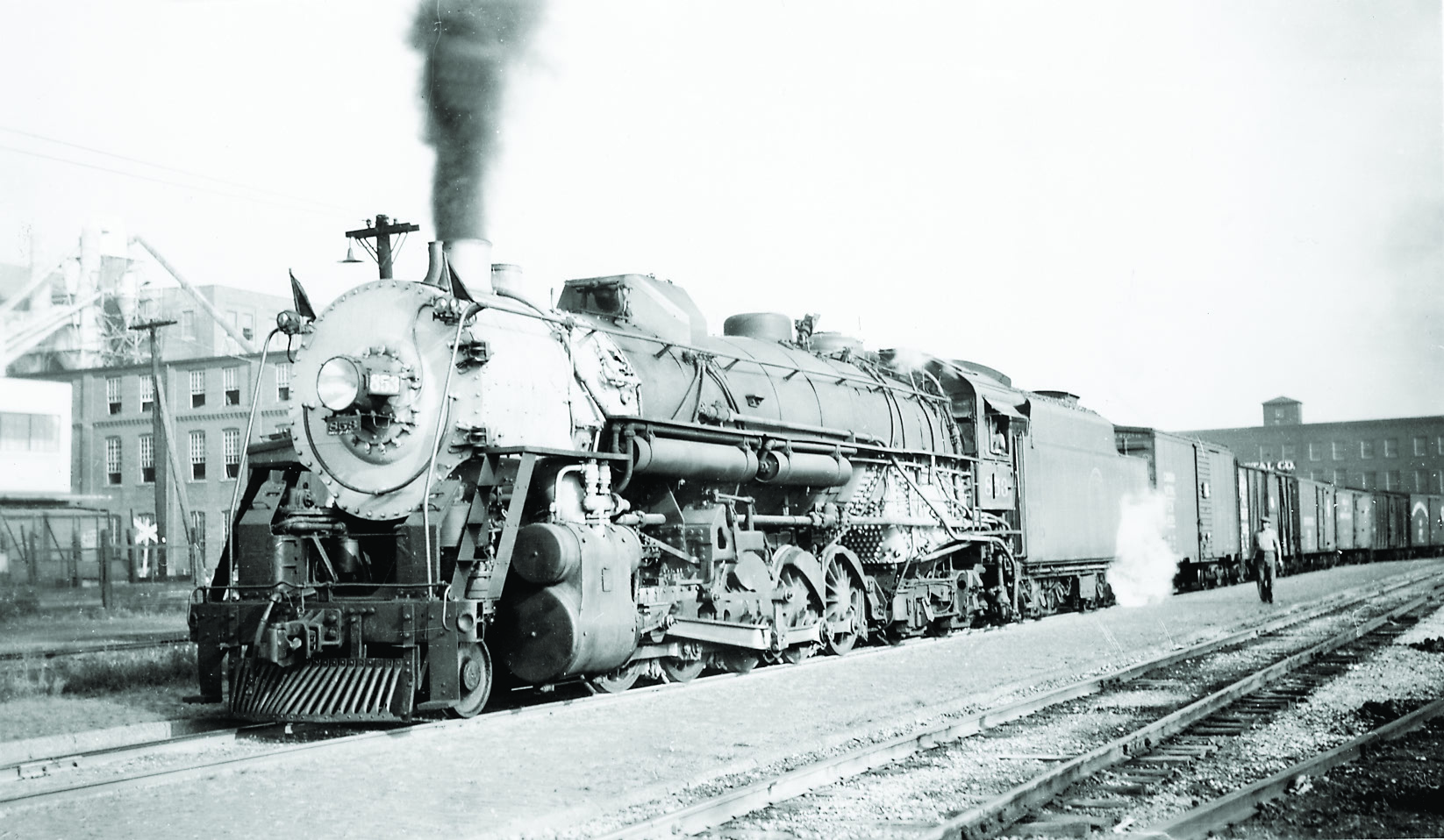 Steam locomotive with freight train in urban setting