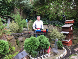 Man standing in garden railway.