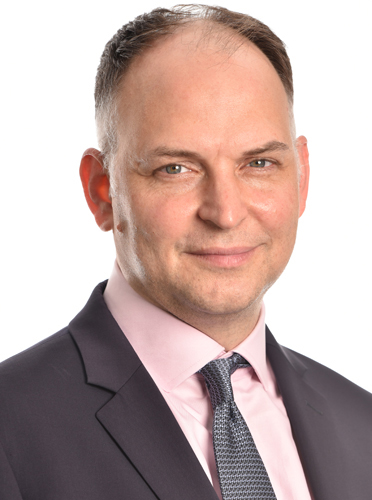 Man with coat, tie, and pink shirt