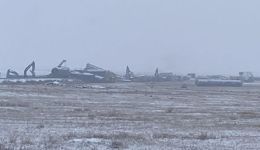 Derailed train cars visible across field