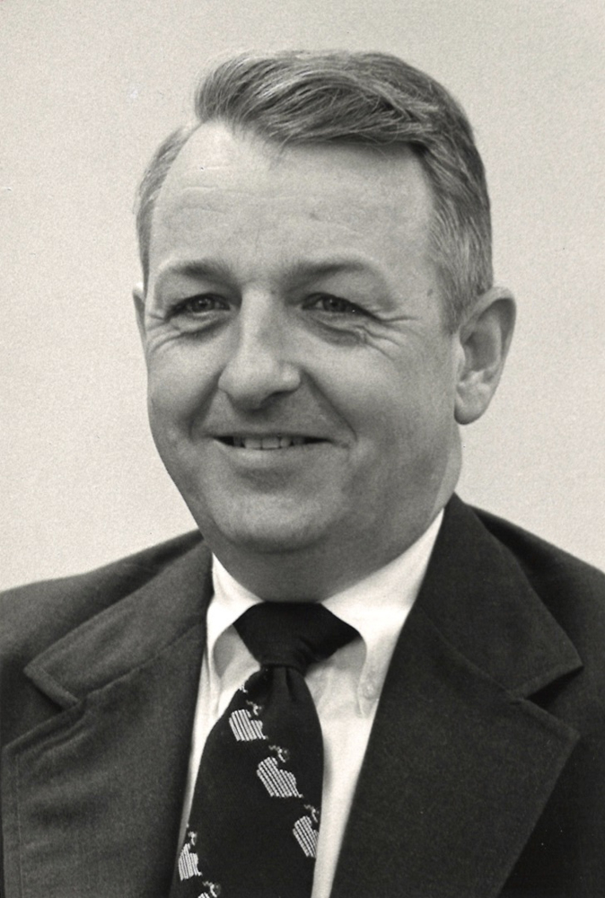 Black and white photo of man in coat and tie