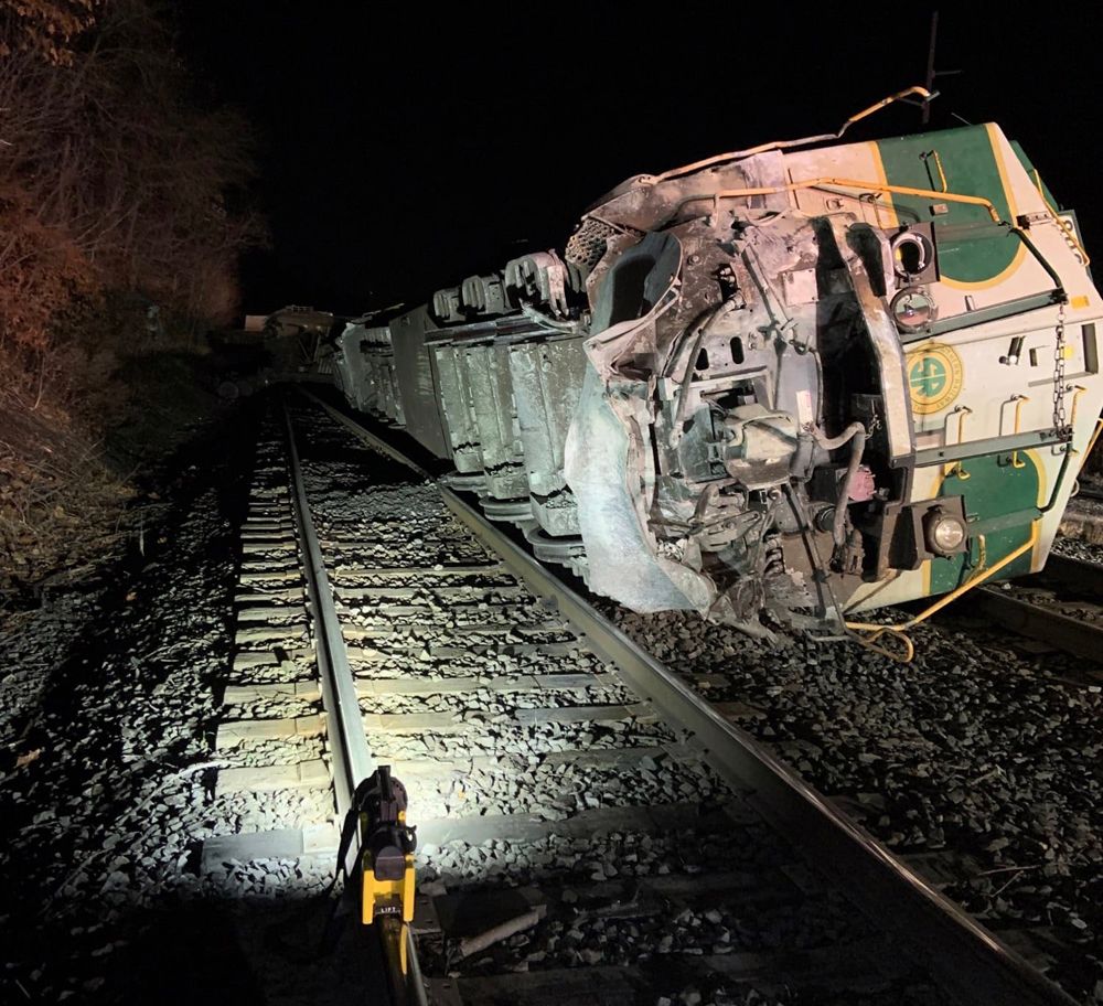 Overturned locomotive illuminated by small light on ground