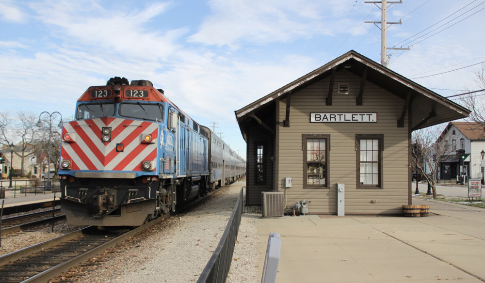 Locomotive next to wood station building