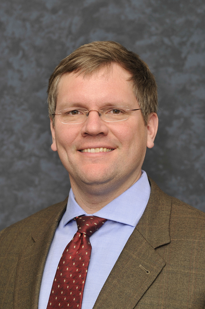 Smiling man in coat and tie