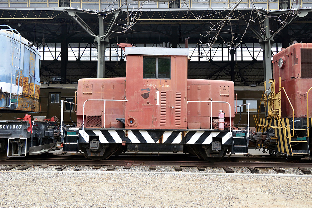 A small, rust-red colored diesel locomotive.