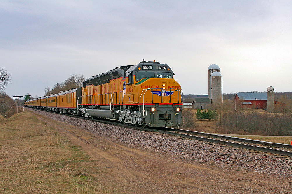 A large yellow Union Pacific diesel locomotive leads a train over the plains.