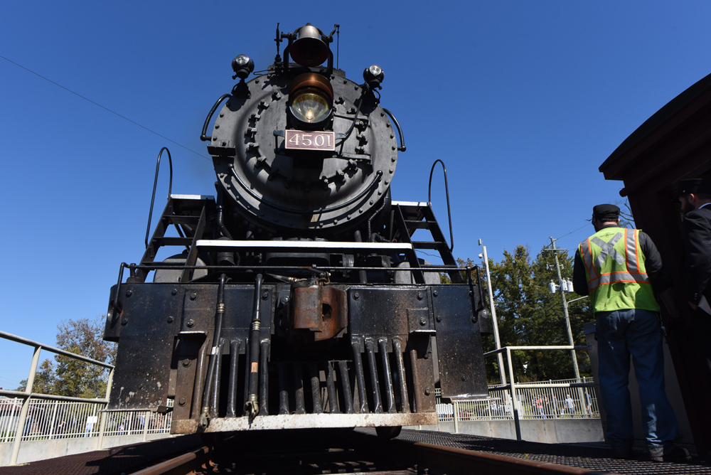 Front view of steam locomotive under blue skies.