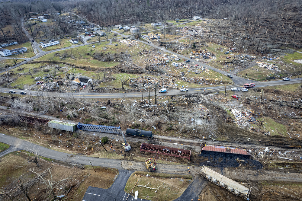 View of derailed cars with debris in background.